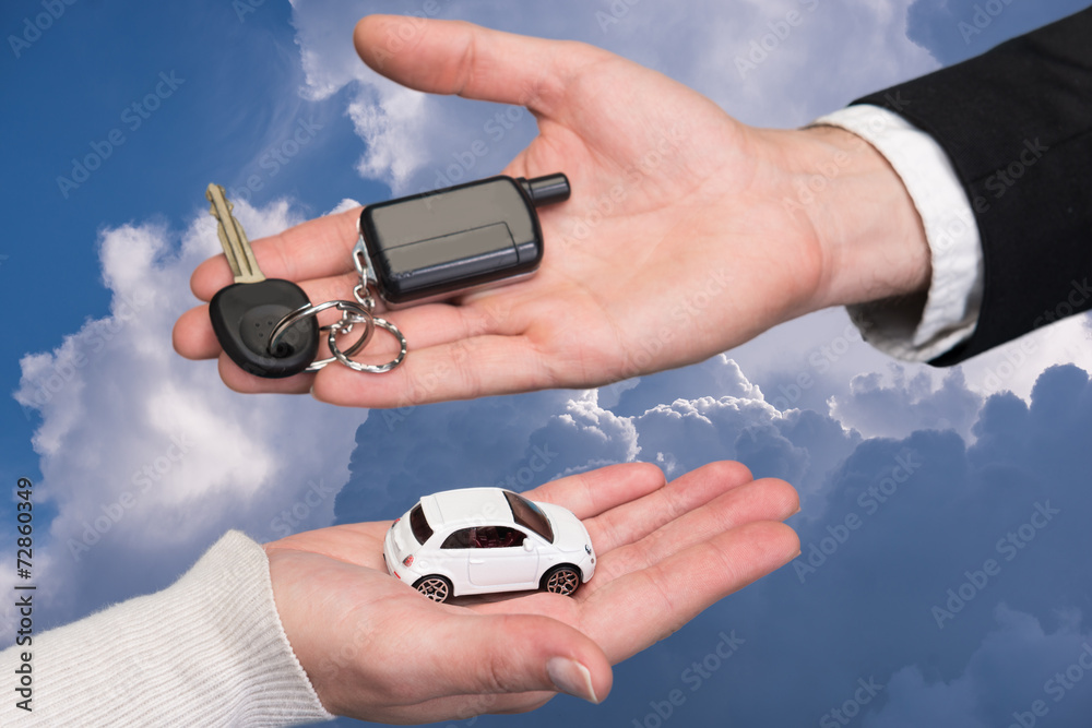 Man holding small car key, woman holding small car