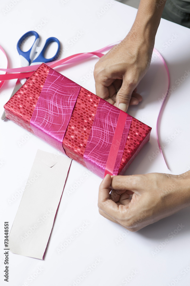 Hands wrapping present on table