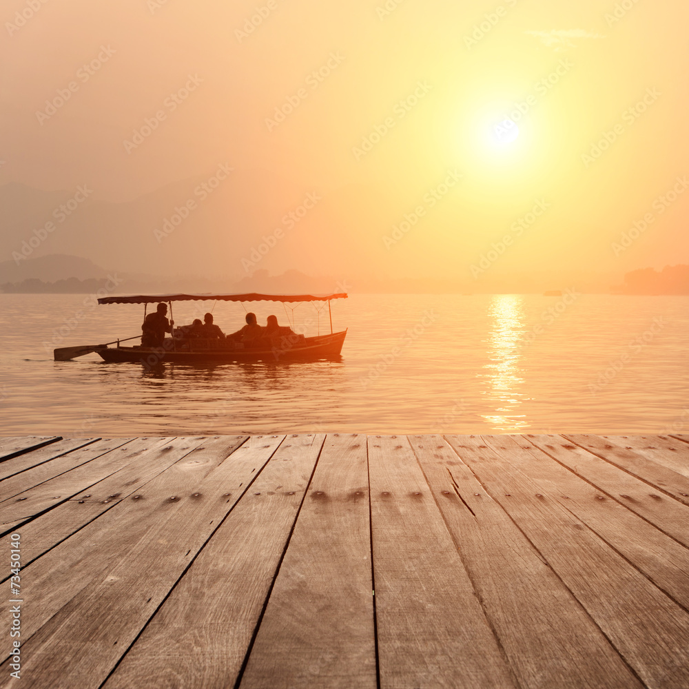 plank board with lake in sunset as background