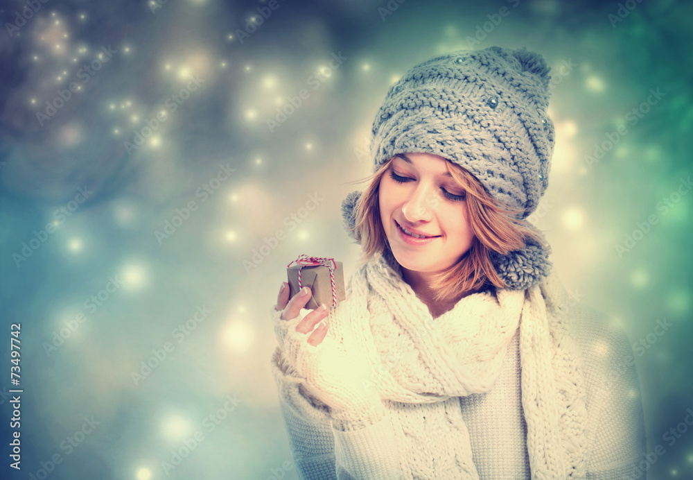 Happy young woman holding a gift box