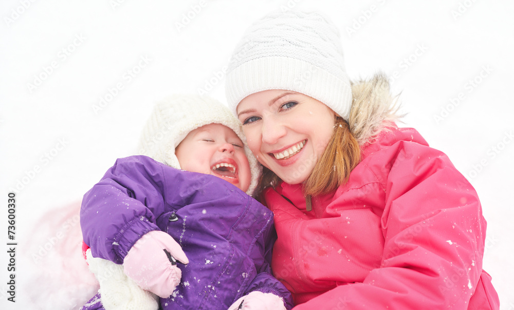 幸福的家庭妈妈和宝贝女儿在冬雪中玩耍