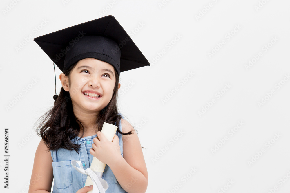 Happy Asian school kid graduate in graduation cap looking up