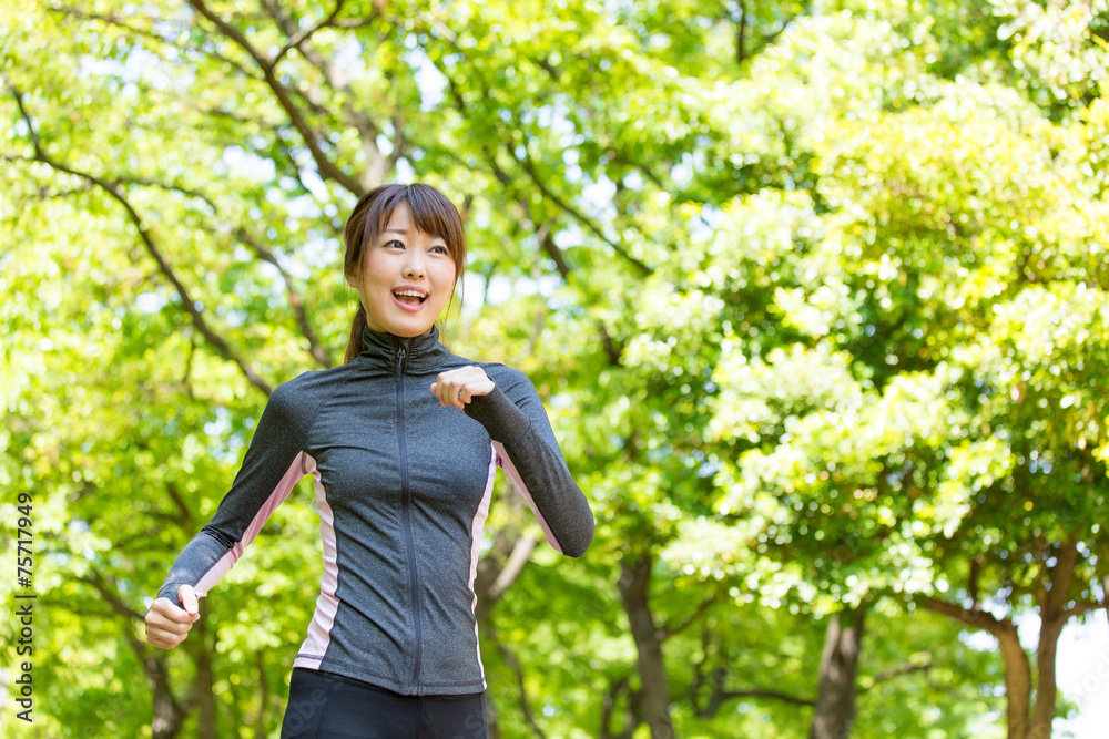 在公园里奔跑的亚洲年轻女子