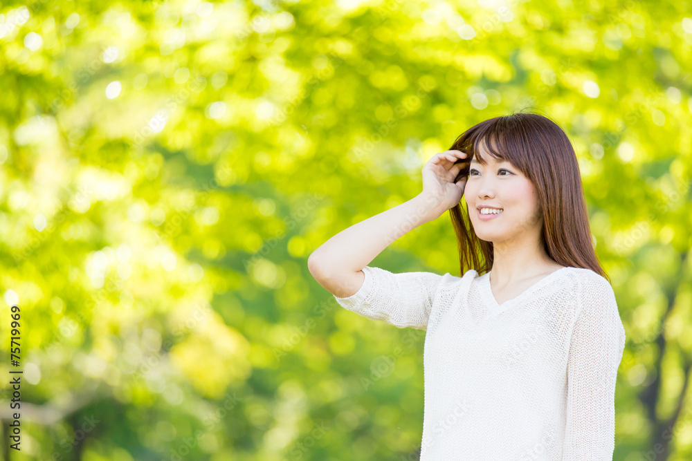 年轻的亚洲女人在公园里放松