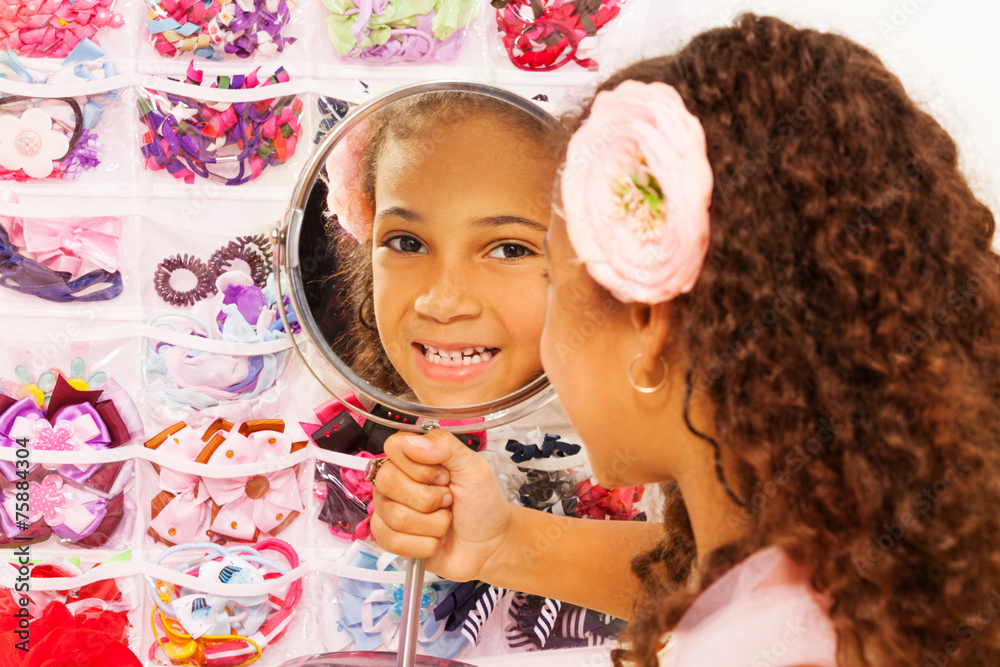 Beautiful small African girl reflects in mirror