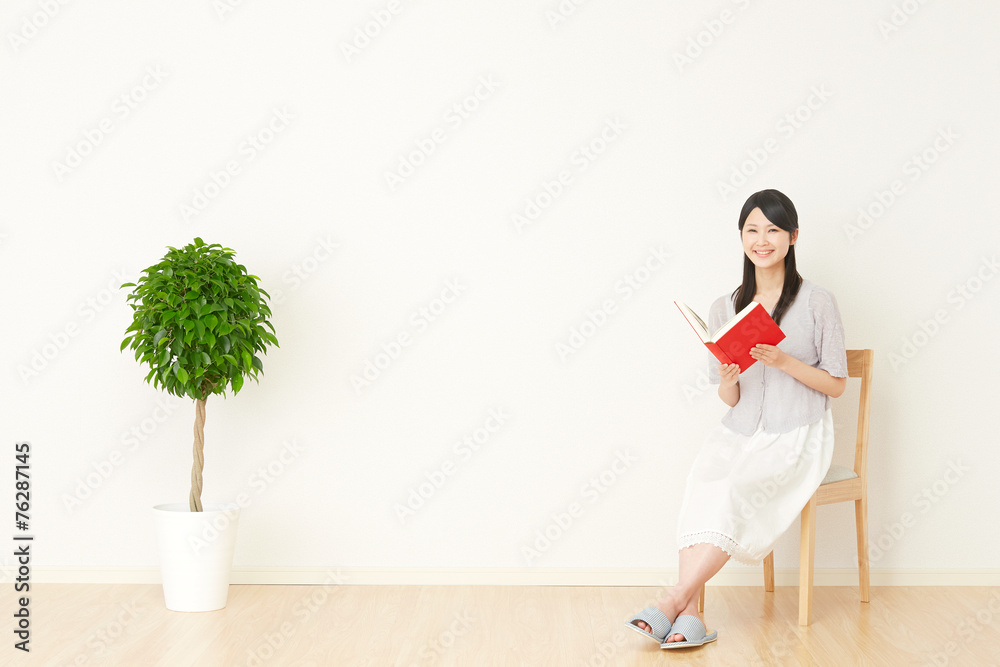 部屋で本を読む女性