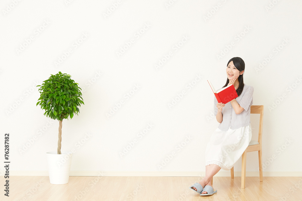 部屋で本を読む女性