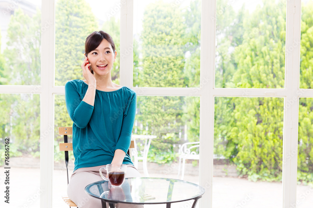 年轻的亚洲女人在咖啡馆放松