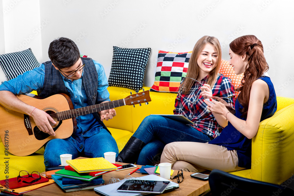 Man playing a guitar with girlfriends