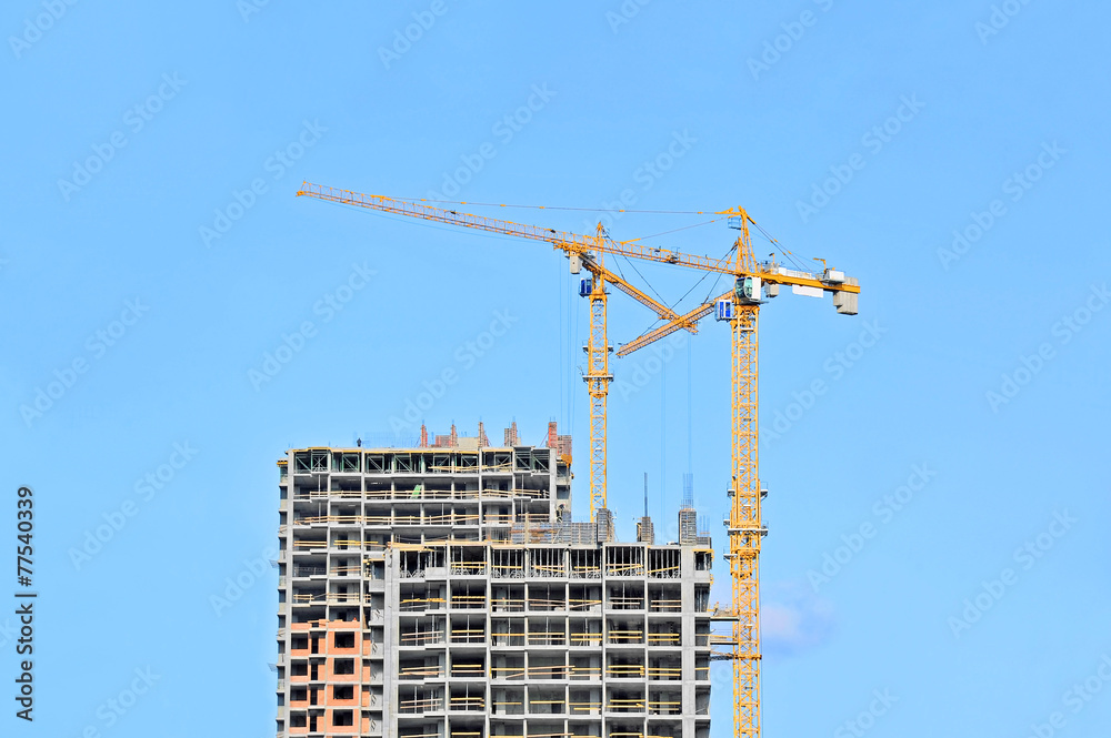 Crane and building construction site against blue sky