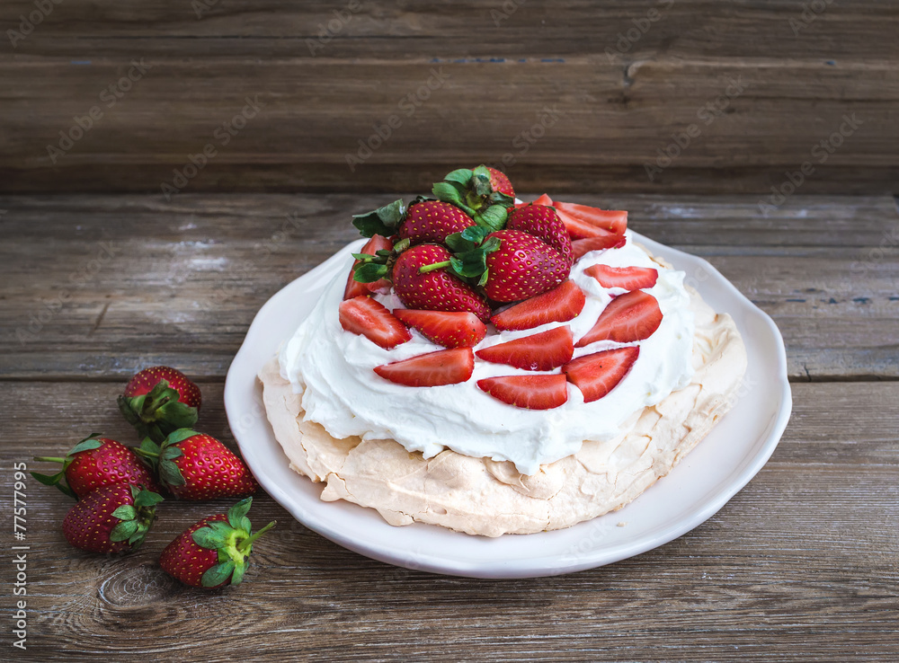 Rustic Pavlova cake with fresh strawberries and whipped cream ov