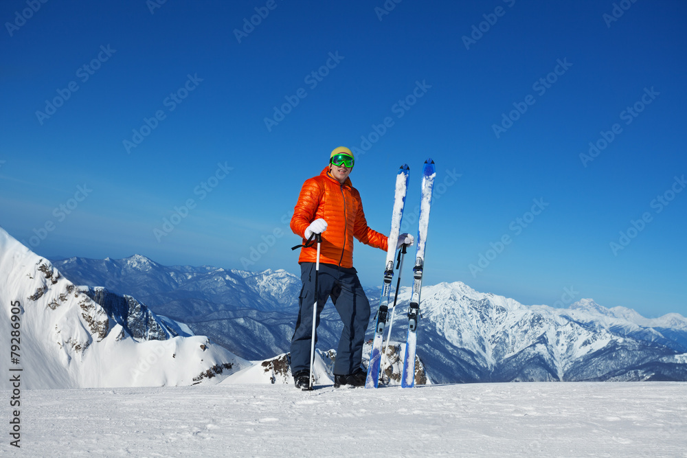 戴着滑雪面罩的男人站在那里，欣赏美丽的山景