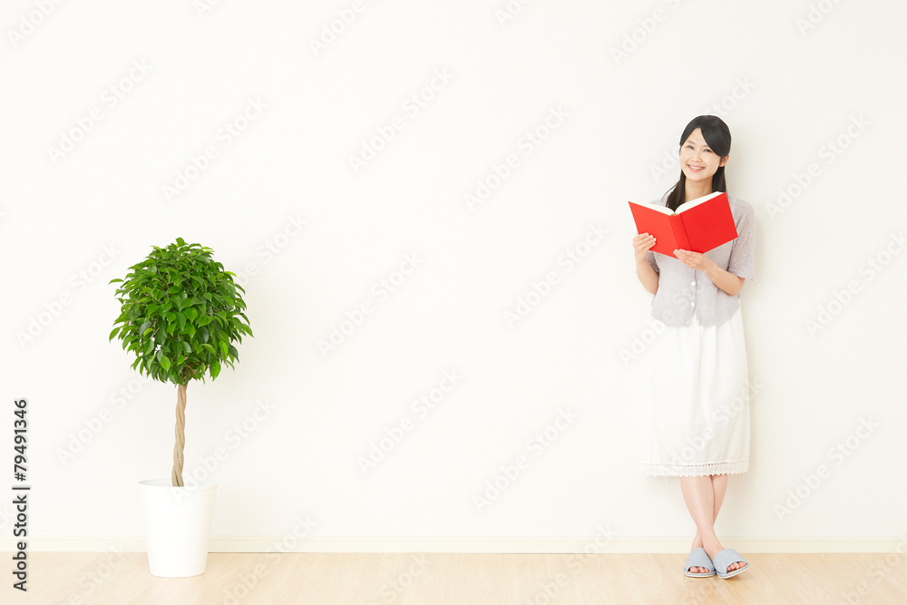 部屋で本を読む女性