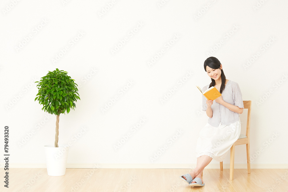 部屋で本を読む女性