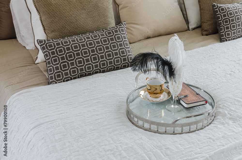 round glass tray of cup and book on bed