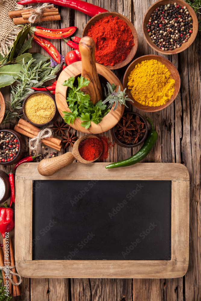 Various spices on wood with blackboard