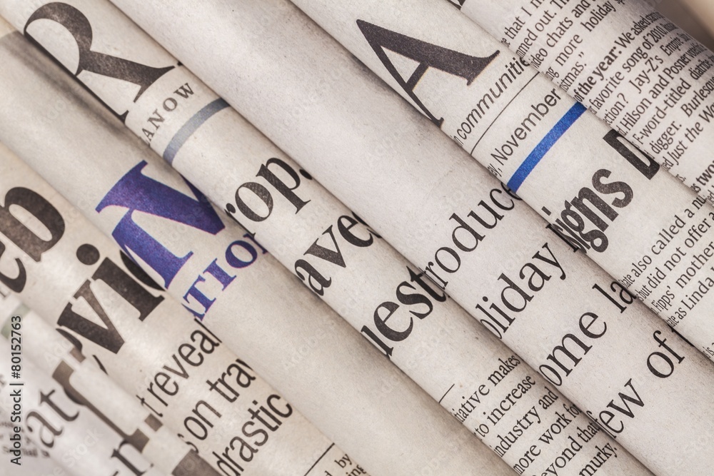 Stack. Newspaper headlines shown side on in a stack of daily