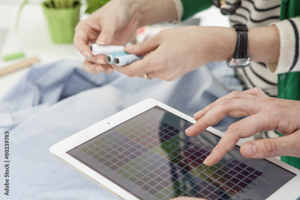 Women are viewing the color swatch in the tablet