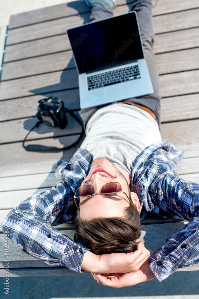 Young photographer with laptop and photo camera