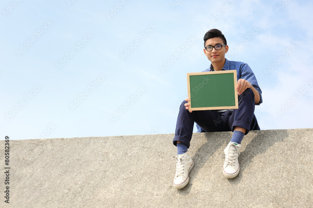 Happy man holding blackboard