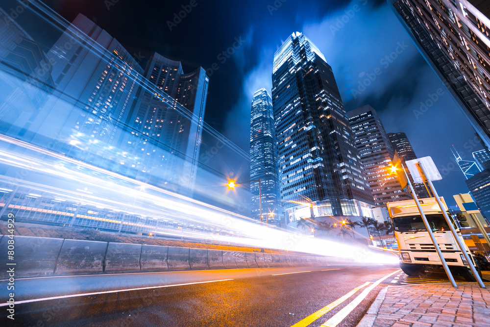 Busy traffic light trails and office buildings.