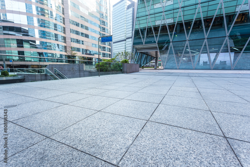 Empty pavement by the side of office building