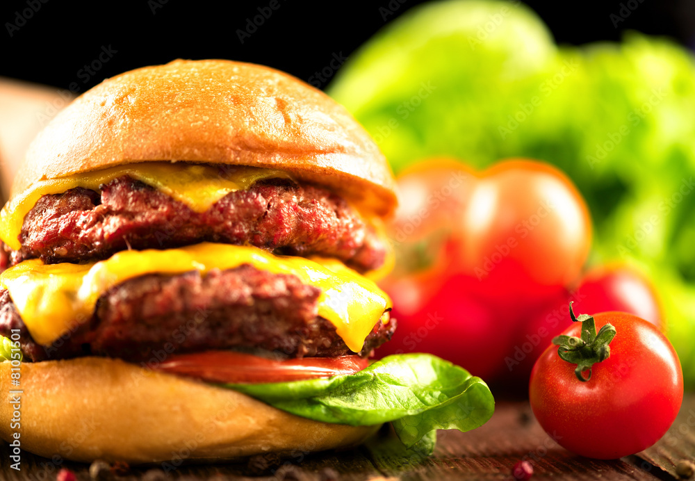 Cheeseburger with fries on wooden table