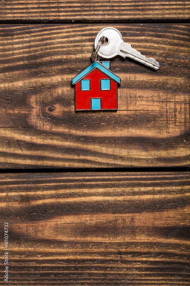 Key. Symbol of the house with silver key on vintage wooden