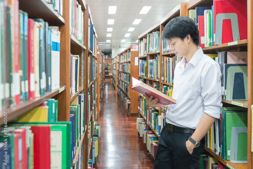 穿着制服的亚洲学生在大学图书馆阅读