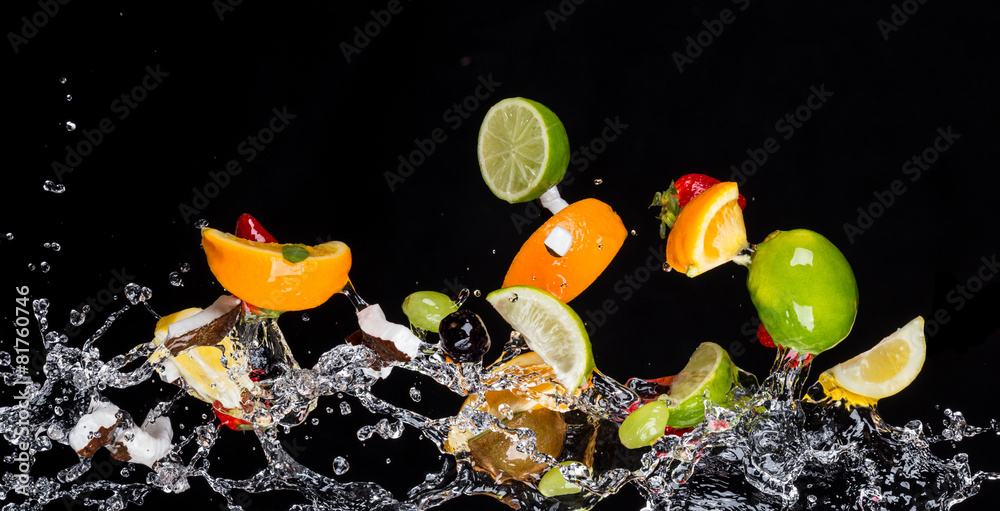 Mix of fruits with water splashes on black