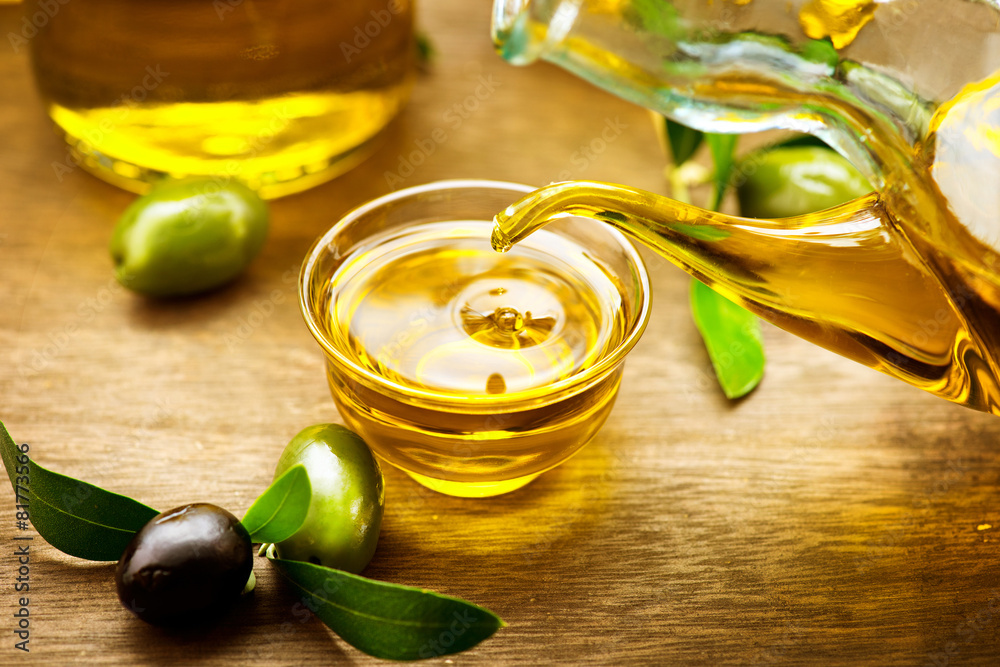 Virgin olive oil pouring in a bowl close up