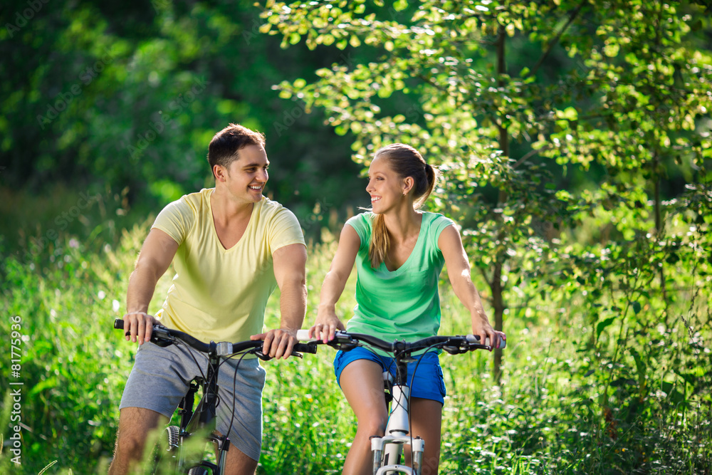 Young couple on bicycles in the park