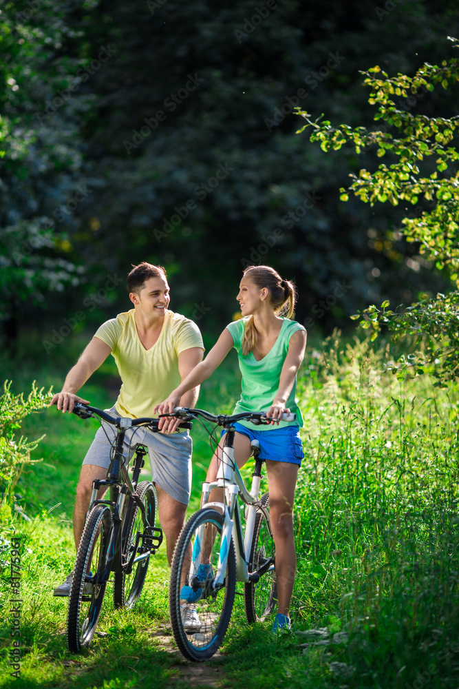 Young couple on bicycles outdoors