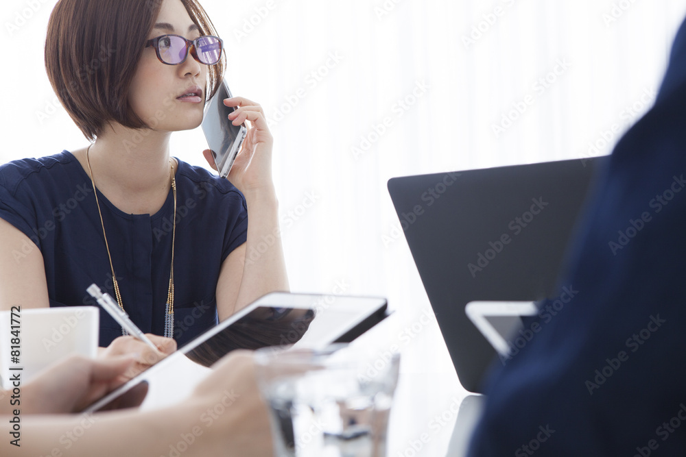 Women who are on the phone during a meeting