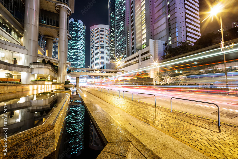 traffic light trails and office buildings in modern city