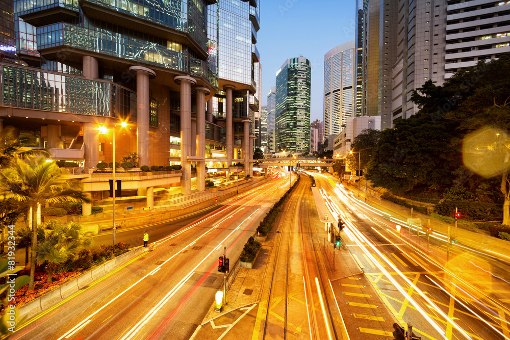 traffic light trails and office buildings in modern city