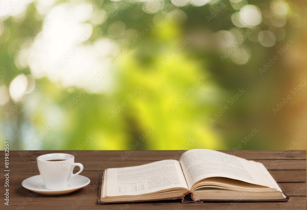 Book. Cup of coffee and a book on a wooden table