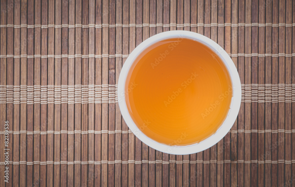 Cup of Chinese hot tea on bamboo mat background