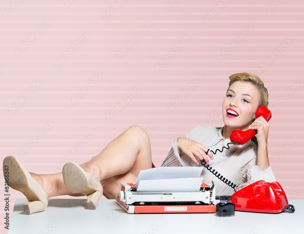 Humour. Business woman puts her feet up on her desk on the phone