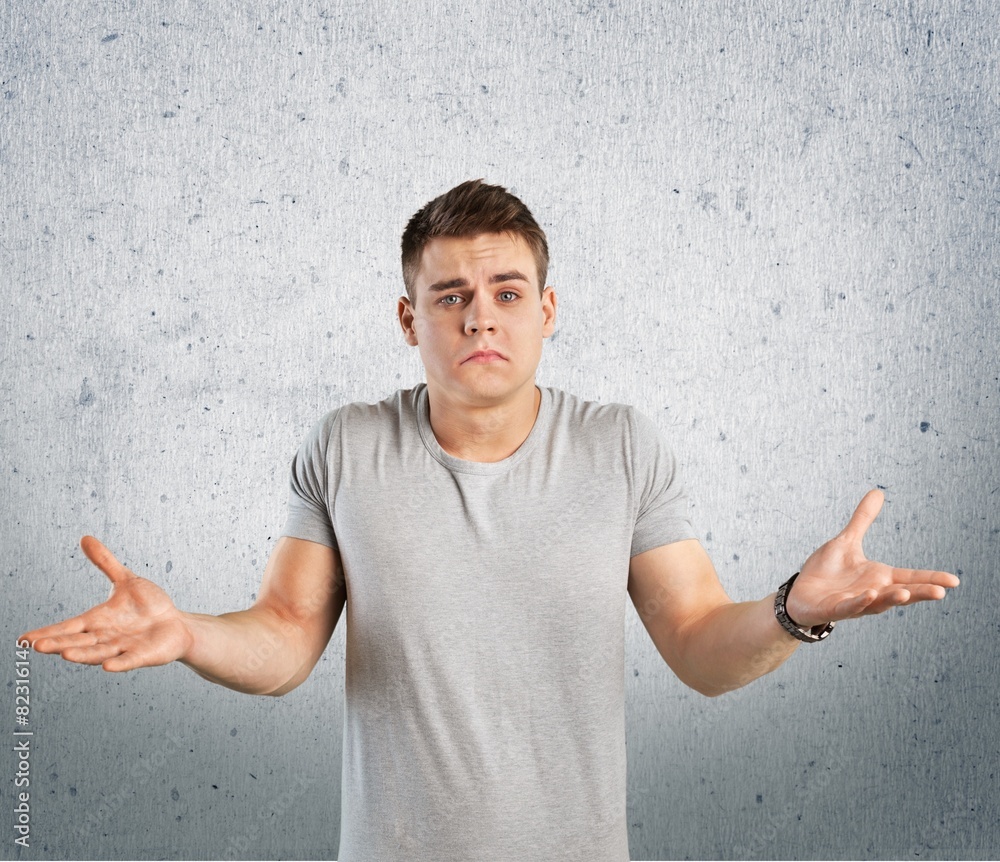 Question. Closeup portrait of dumb clueless young man, arms out