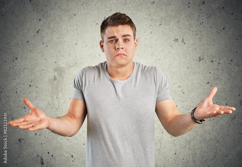 Question. Closeup portrait of dumb clueless young man, arms out