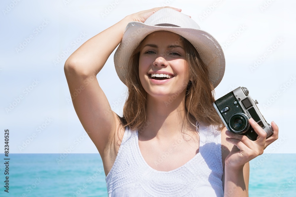 海滩。海滩女人带着复古相机玩得很开心