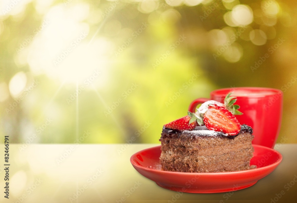 Closeup. Delicious chocolate cake with cream and berries and cup