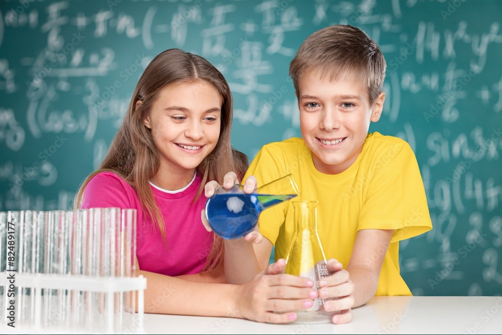 Project. Young school kids doing a chemistry experiment with the