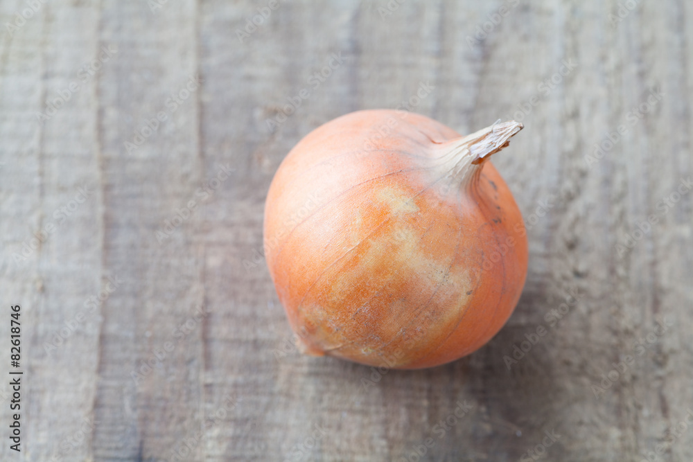 Small fresh gold onion on wood background