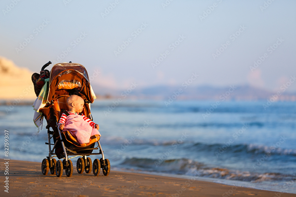 Baby in a stroller on a sandy beach