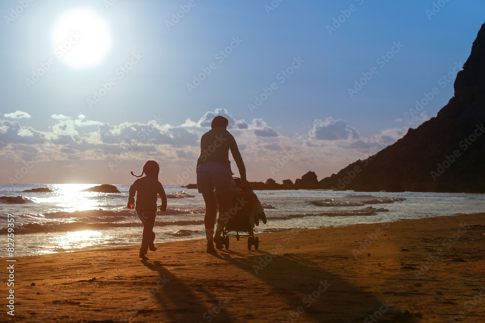 Mother with her daughter and baby on a sandy beach