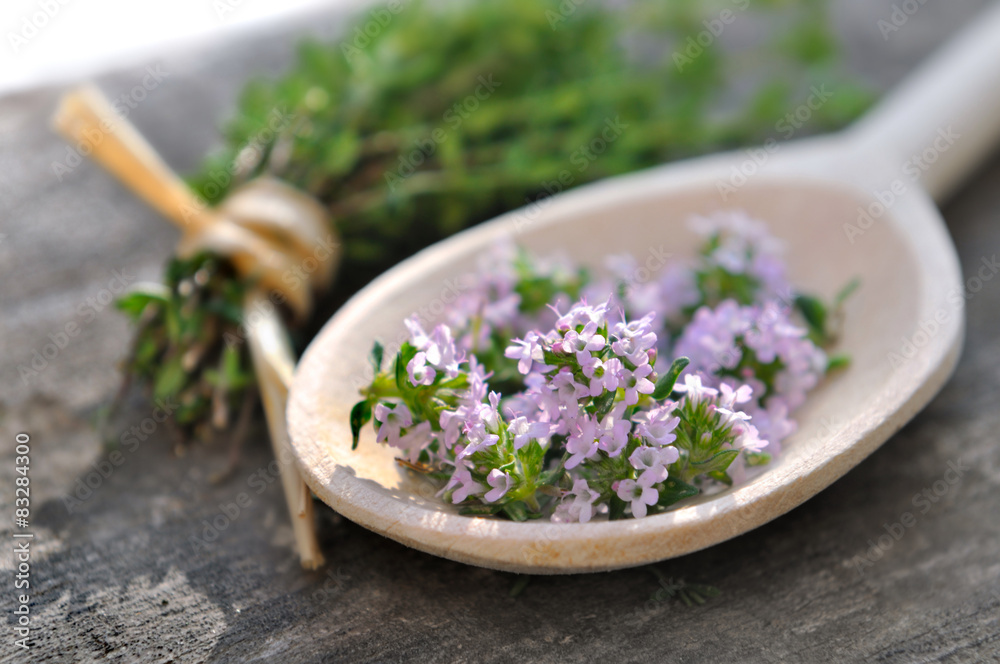 fleurs de thym dans cuillère en bois sur planche 