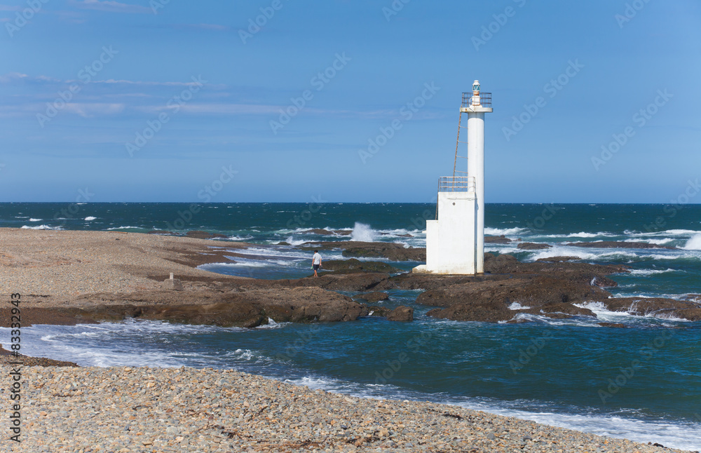 Lighthouse on the beach against blue sky