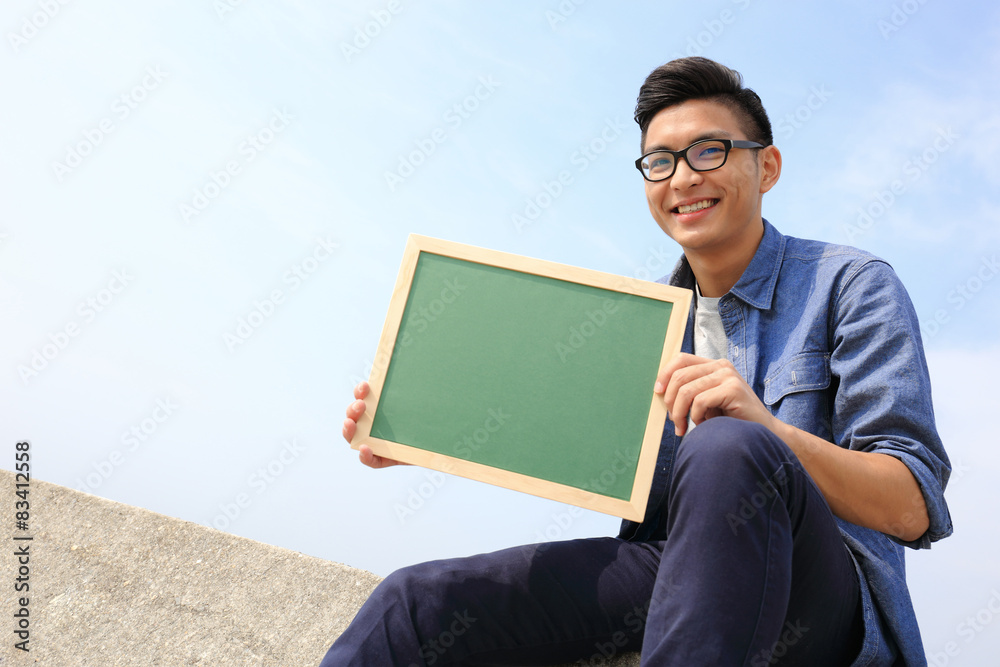 Happy man holding blackboard